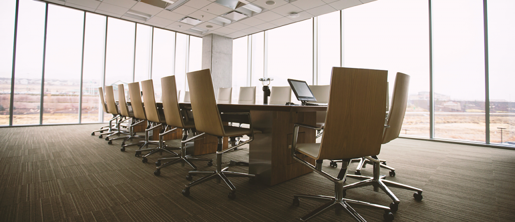 oval brown table and chairs inside conference room